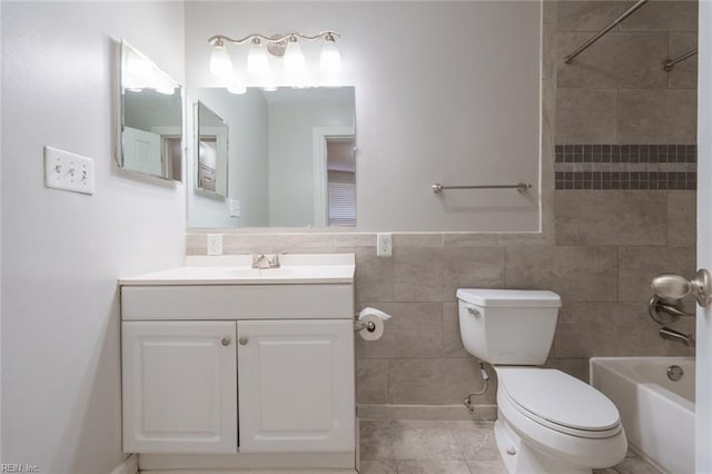 full bathroom featuring toilet, tiled shower / bath, tile walls, vanity, and tile patterned flooring