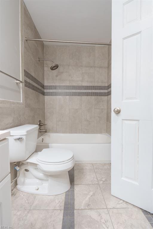 full bathroom featuring vanity, tiled shower / bath, tile walls, and toilet