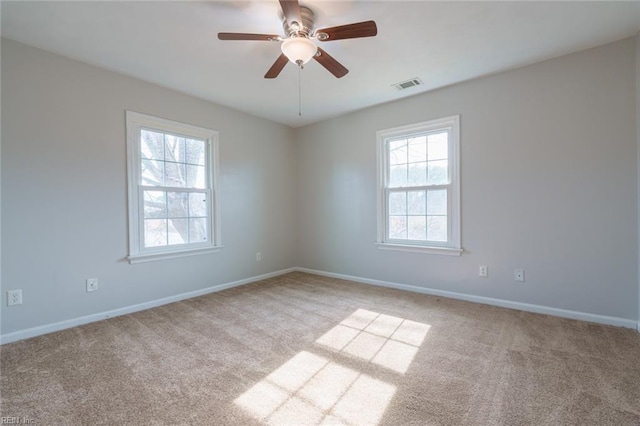 carpeted empty room featuring ceiling fan and a healthy amount of sunlight