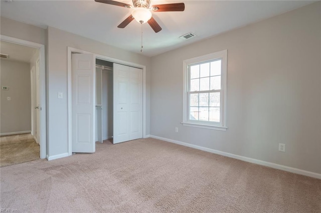 unfurnished bedroom featuring light colored carpet, a closet, and ceiling fan