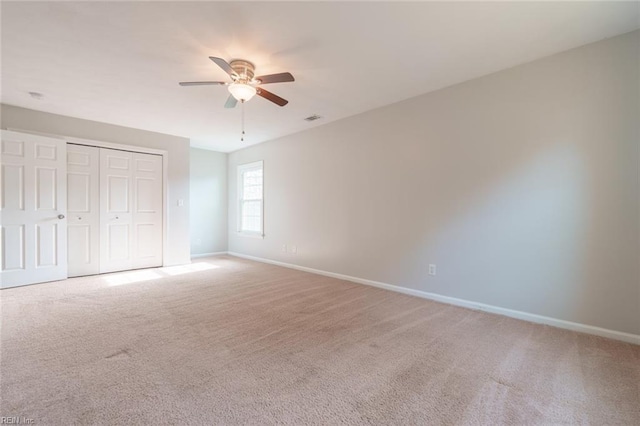 unfurnished bedroom with ceiling fan, a closet, and light carpet