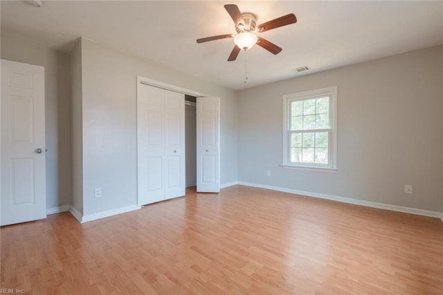 unfurnished bedroom with ceiling fan, a closet, and light wood-type flooring