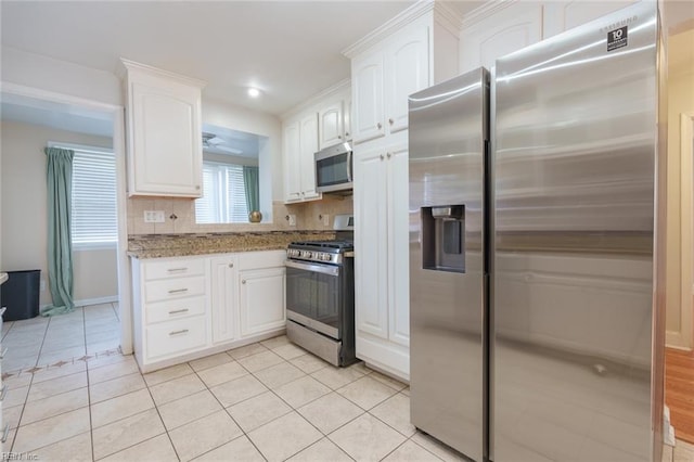 kitchen featuring white cabinetry, light stone counters, stainless steel appliances, and light tile patterned flooring