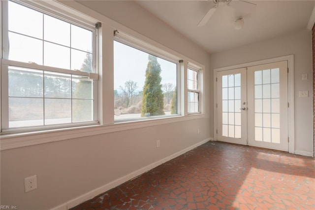 unfurnished sunroom with french doors, ceiling fan, and a healthy amount of sunlight