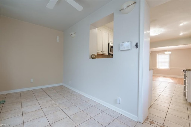 tiled empty room featuring ceiling fan