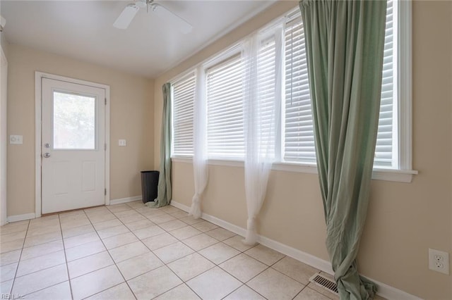 entryway featuring light tile patterned flooring, a healthy amount of sunlight, and ceiling fan