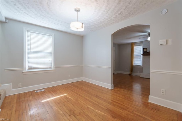 spare room with ceiling fan, wood-type flooring, and a textured ceiling