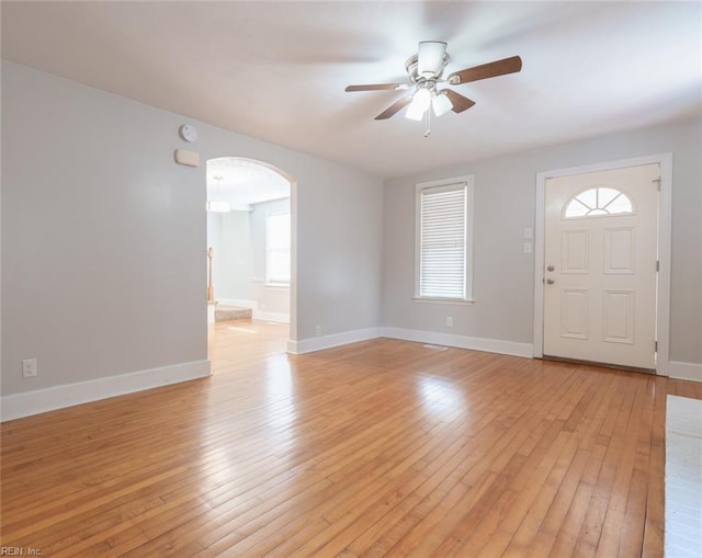 entryway featuring a wealth of natural light, ceiling fan, and light hardwood / wood-style flooring