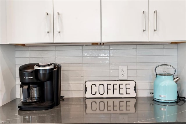 room details with stainless steel counters, white cabinets, and backsplash