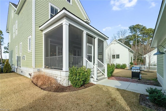 exterior space with a lawn and a sunroom