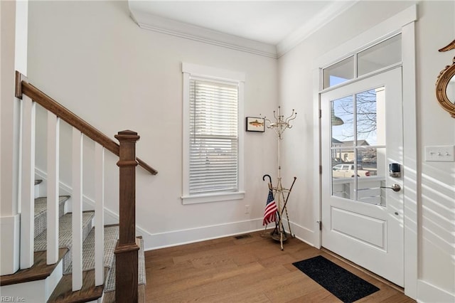 foyer with crown molding, a wealth of natural light, and hardwood / wood-style flooring