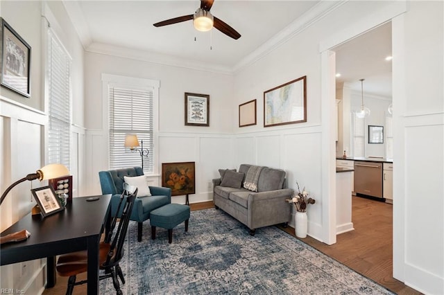 living area with ceiling fan, ornamental molding, and dark hardwood / wood-style floors