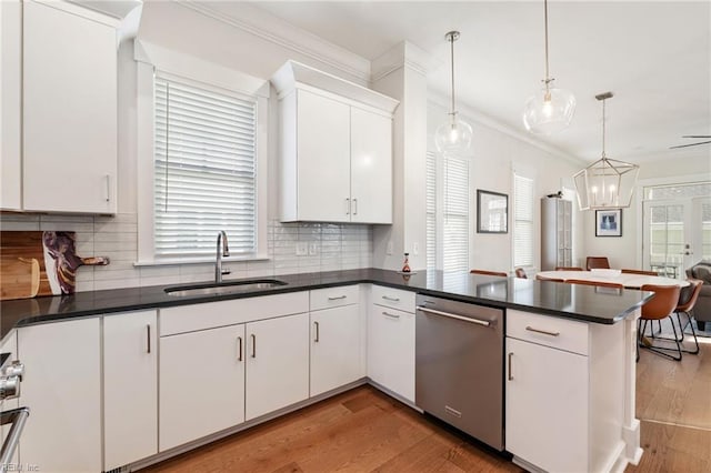 kitchen with sink, white cabinetry, dishwasher, kitchen peninsula, and pendant lighting