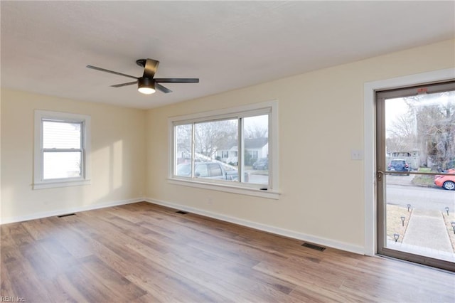 spare room with ceiling fan and light wood-type flooring