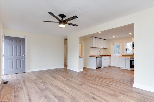 unfurnished living room with ceiling fan, sink, and light hardwood / wood-style floors