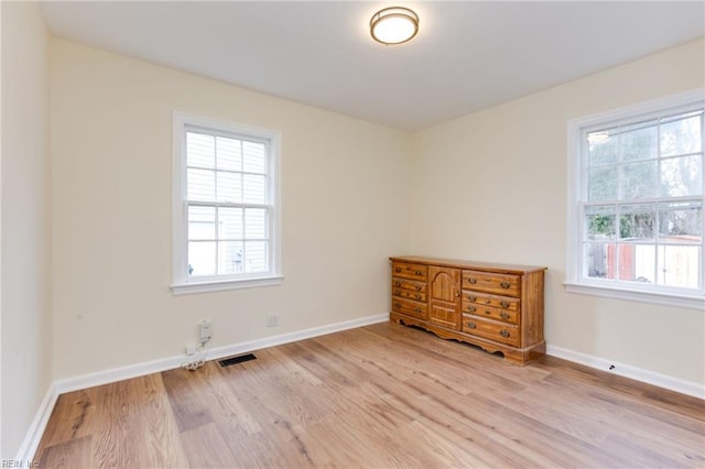 unfurnished room featuring plenty of natural light and light hardwood / wood-style floors