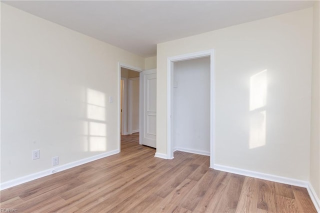 unfurnished bedroom featuring light hardwood / wood-style floors and a closet