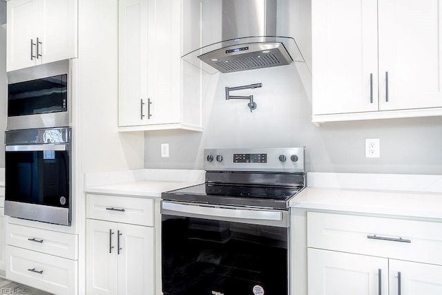 1825 Broadstreet Rd, Hampton, VA 23666 - kitchen with wall chimney exhaust hood, appliances with stainless steel finishes, and white cabinetry