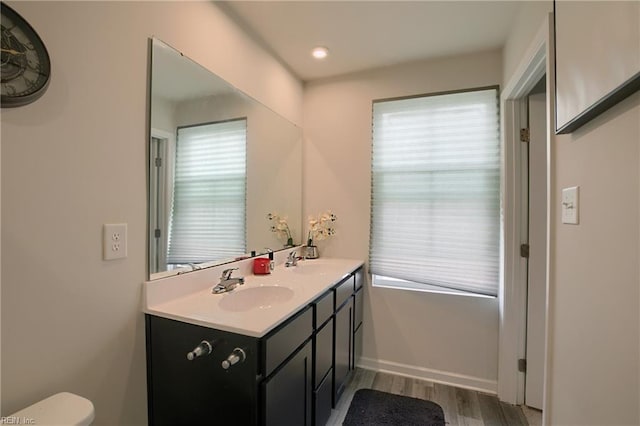 bathroom with plenty of natural light, toilet, hardwood / wood-style floors, and vanity