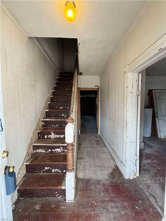 stairs with a textured ceiling