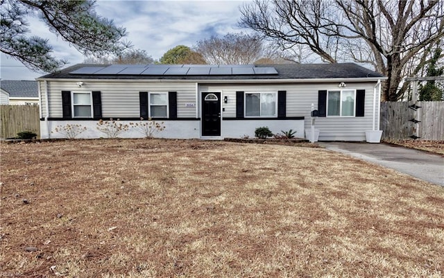 ranch-style house with a front yard and solar panels