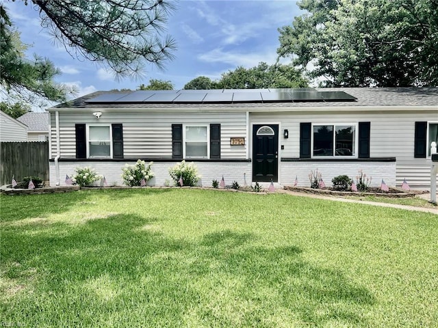 single story home featuring a front yard and solar panels