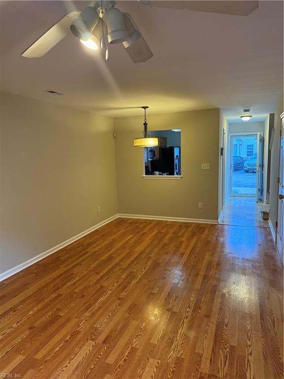 unfurnished living room with ceiling fan and wood-type flooring