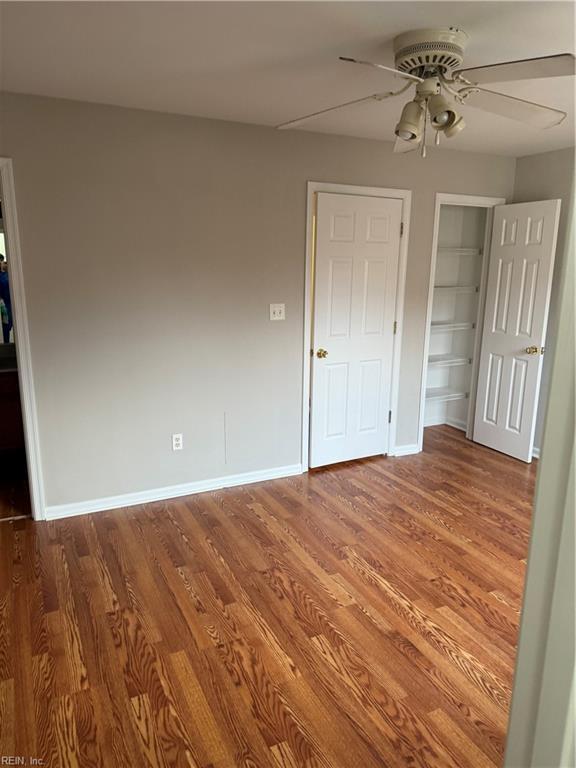 unfurnished bedroom with hardwood / wood-style floors, a closet, and ceiling fan