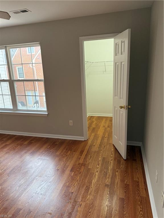 spare room with dark wood-type flooring and ceiling fan