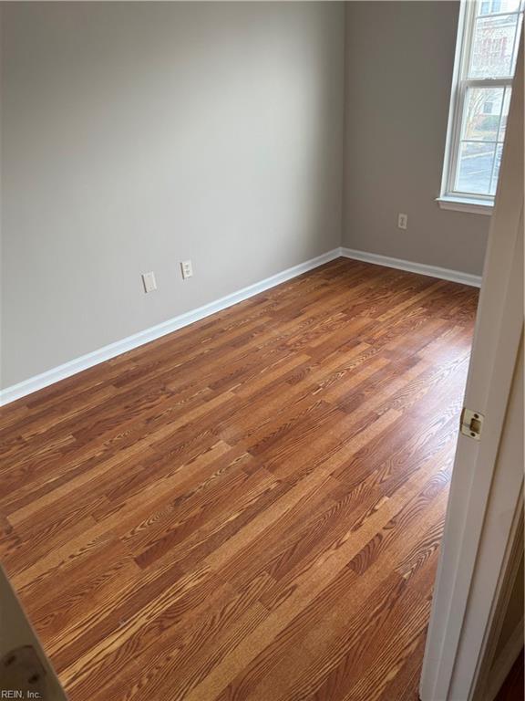 unfurnished room with wood-type flooring