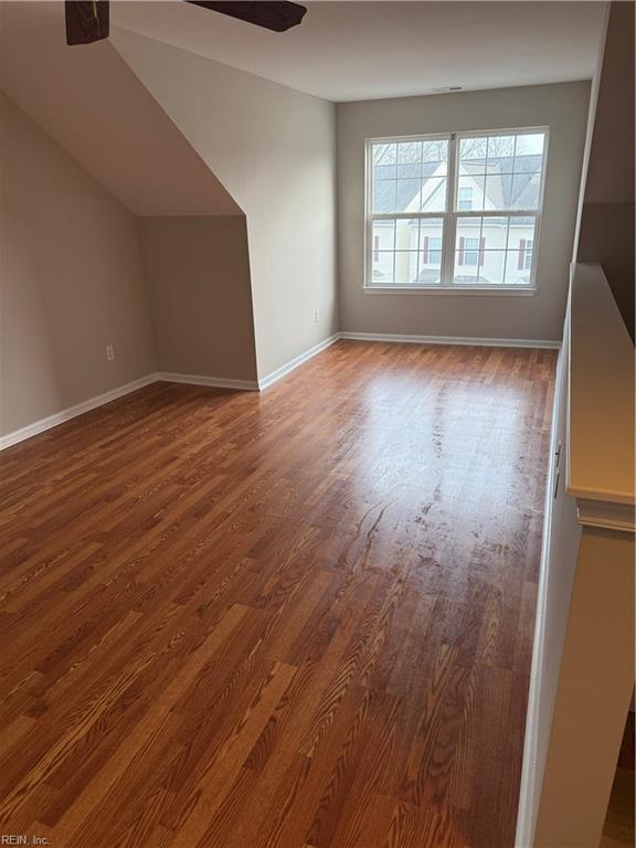 additional living space with dark hardwood / wood-style flooring and ceiling fan