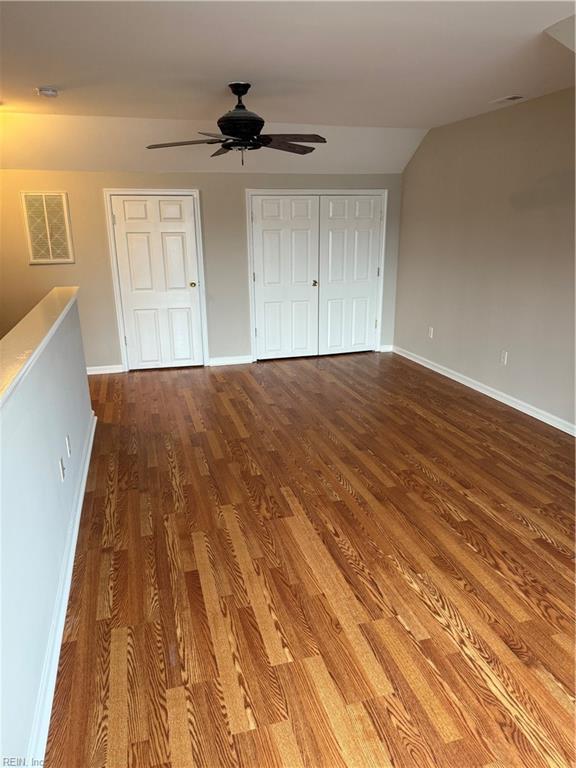 unfurnished bedroom with hardwood / wood-style flooring, ceiling fan, and lofted ceiling