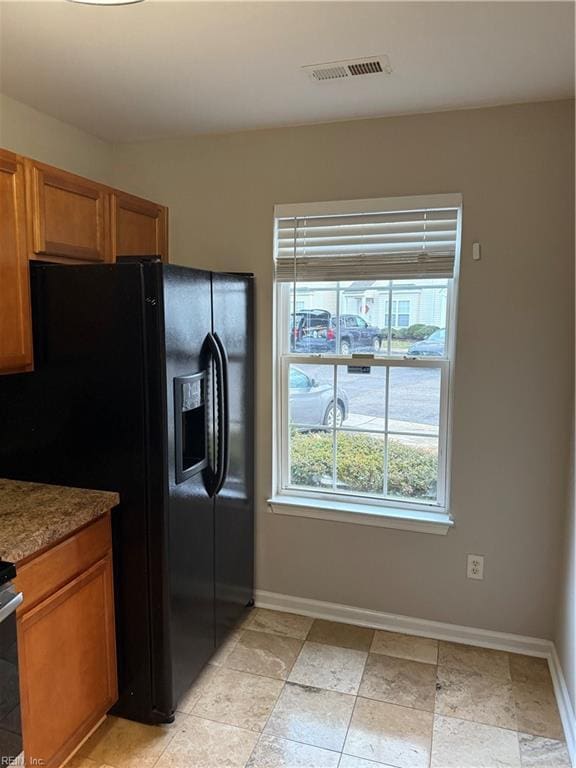 kitchen featuring black refrigerator with ice dispenser