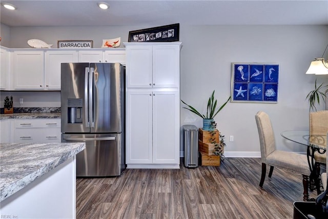 kitchen with stainless steel fridge, dark hardwood / wood-style floors, and white cabinets