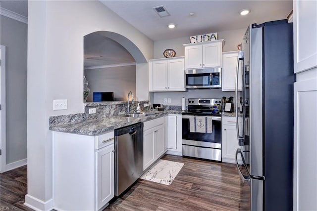 kitchen with sink, light stone countertops, white cabinets, and appliances with stainless steel finishes