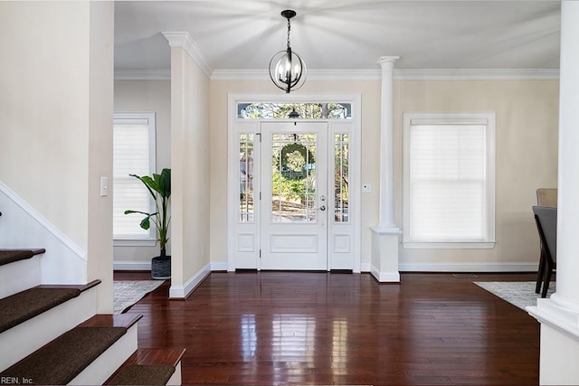 foyer with crown molding, dark hardwood / wood-style floors, and decorative columns