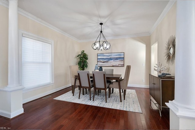 dining room with crown molding, dark hardwood / wood-style flooring, a chandelier, and decorative columns