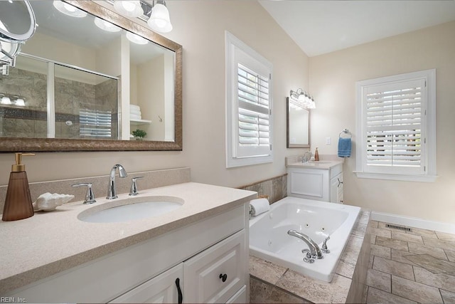 bathroom featuring vanity, a wealth of natural light, and plus walk in shower