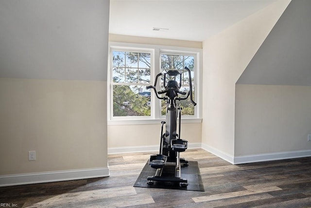 workout room featuring hardwood / wood-style flooring and vaulted ceiling