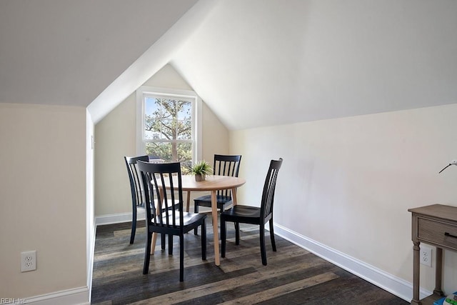 dining area featuring dark hardwood / wood-style flooring and vaulted ceiling