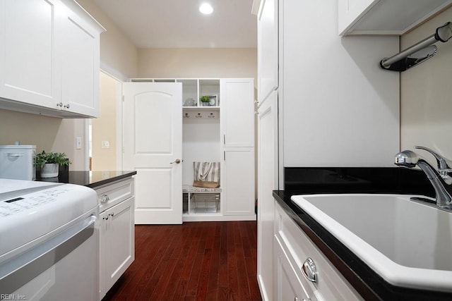 laundry room with cabinets, dark hardwood / wood-style floors, and sink