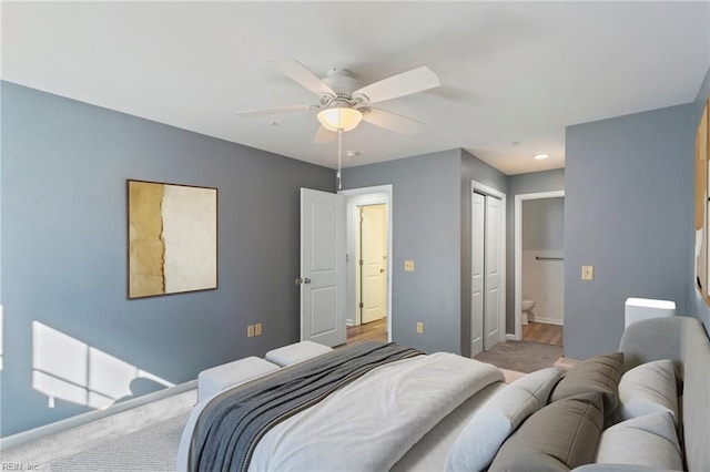 carpeted bedroom with a closet, ceiling fan, and ensuite bathroom