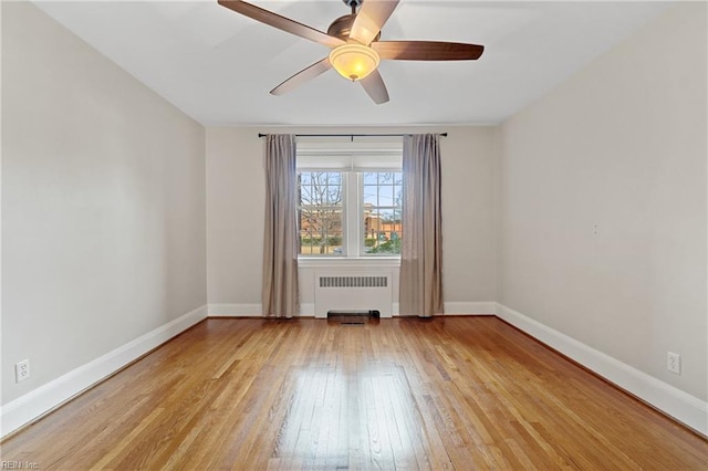 unfurnished room with radiator, light hardwood / wood-style flooring, and ceiling fan