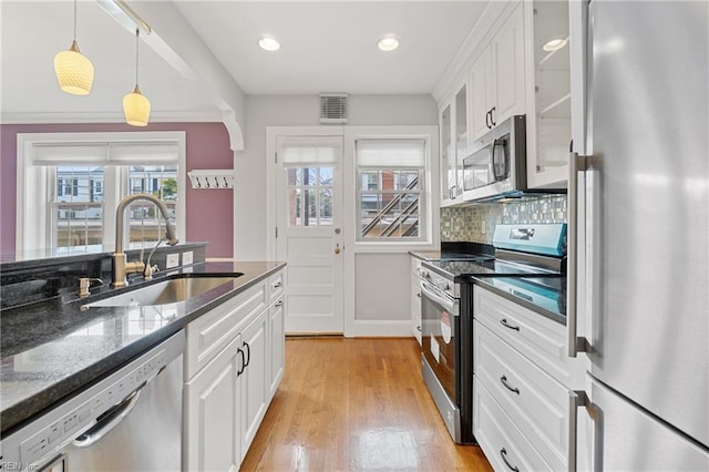 kitchen with sink, hanging light fixtures, white cabinets, and appliances with stainless steel finishes