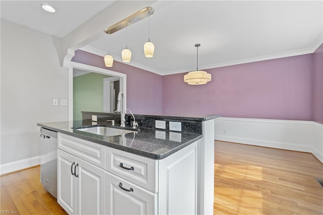 kitchen with pendant lighting, sink, white cabinets, stainless steel dishwasher, and dark stone counters