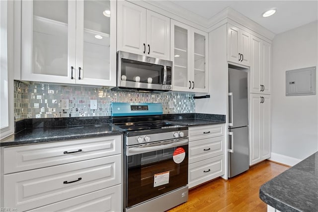 kitchen with stainless steel appliances, white cabinetry, electric panel, and light hardwood / wood-style flooring