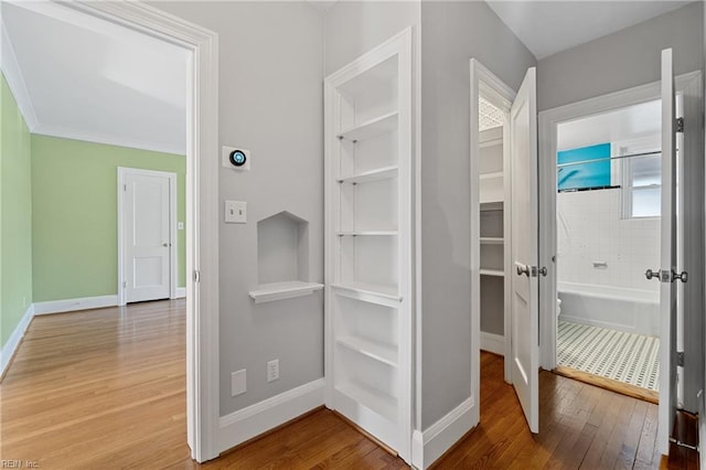 interior space featuring wood-type flooring and crown molding