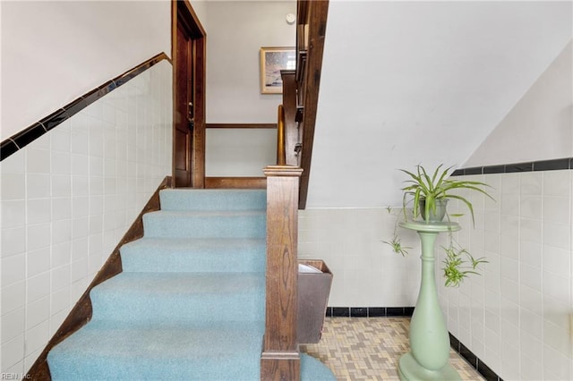 stairs featuring tile walls