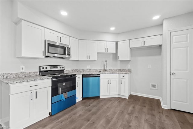 kitchen with hardwood / wood-style flooring, white cabinetry, appliances with stainless steel finishes, and sink