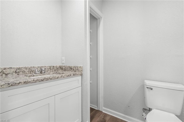 bathroom featuring vanity, hardwood / wood-style floors, and toilet